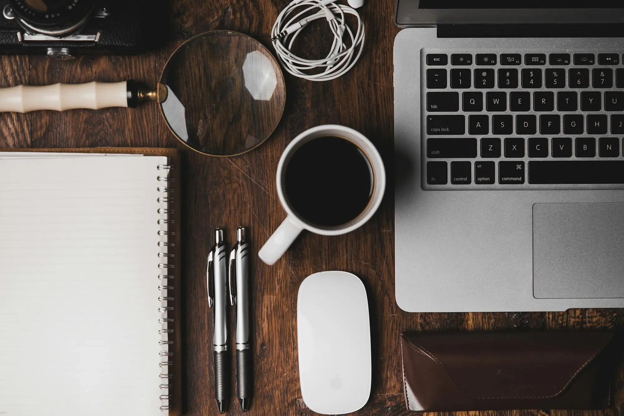 Laptop, notebook and coffee on a desk for a cash flow review