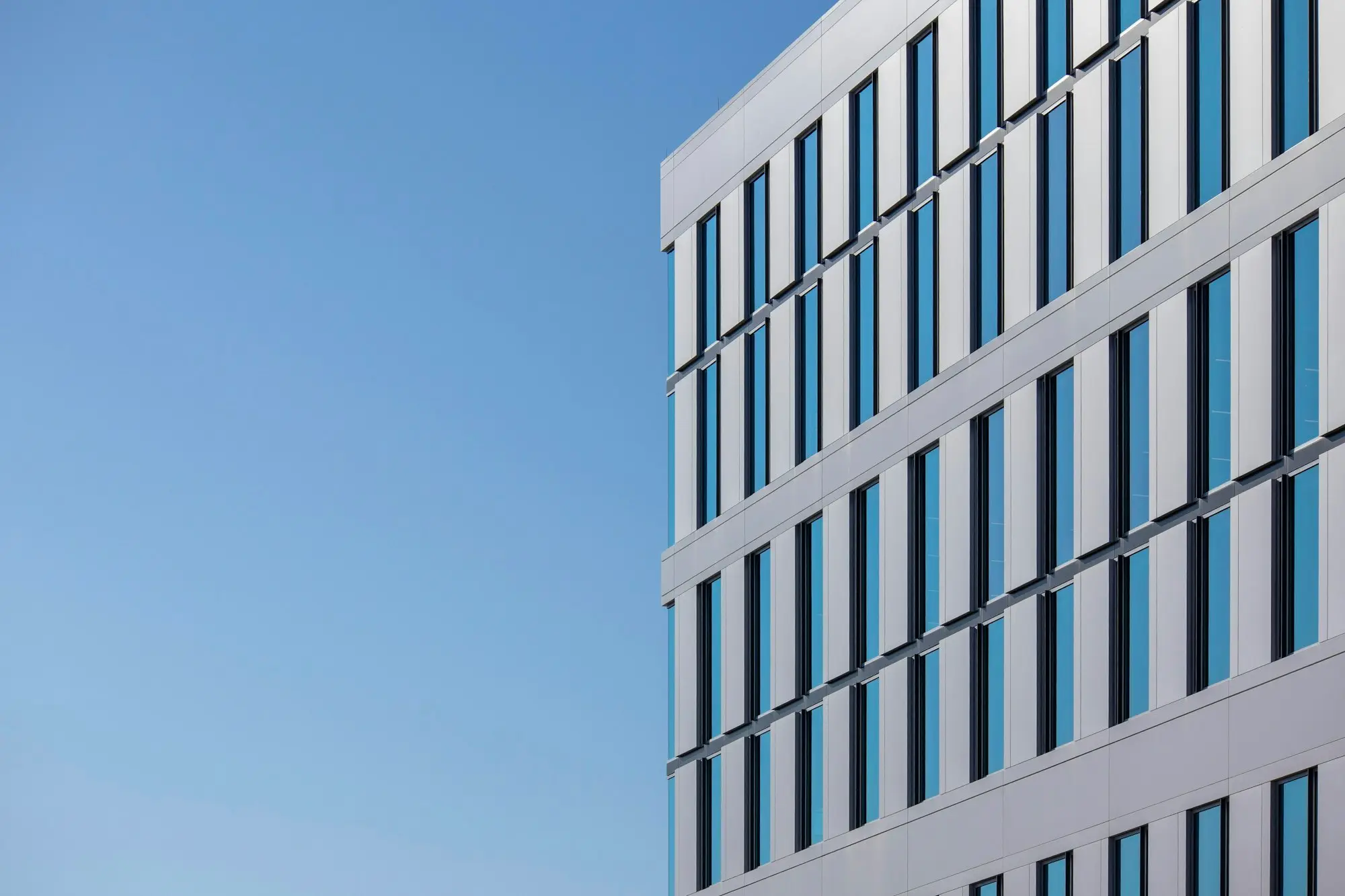 Glass-fronted commercial office building against a blue sky