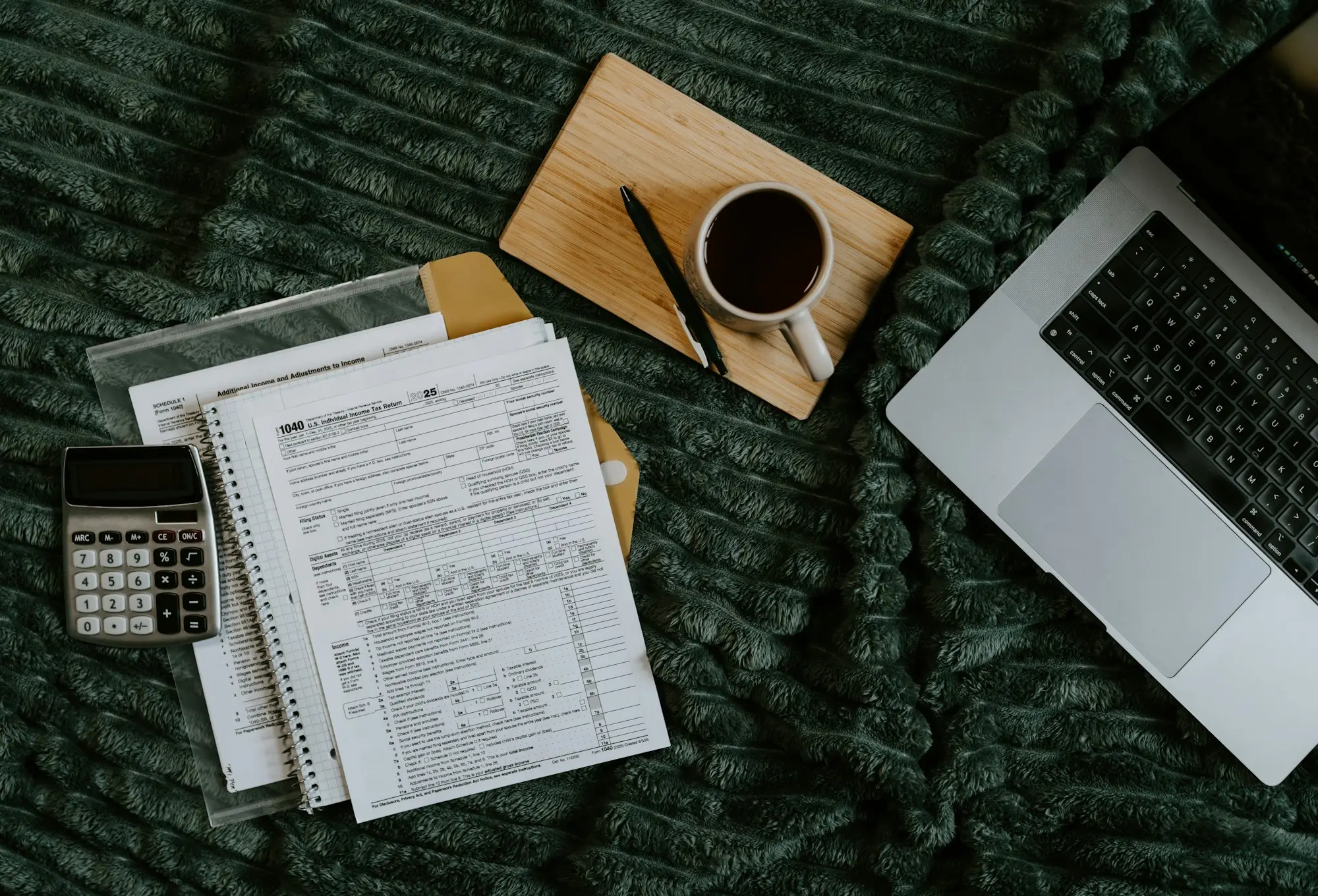 Invoices, laptop and coffee laid out for review in a home office